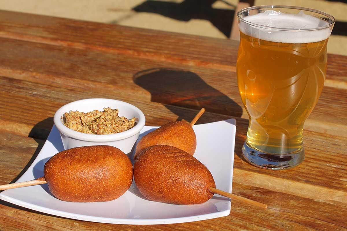 Image of a glass of beer and corndog bites in The Station Public House's unique outdoor dining setting.